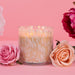 Candle with flowers on a pink background