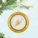 Gold compass ornament with text on a Christmas tree