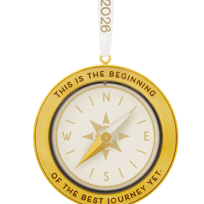 Gold compass ornament with 'This is the beginning of the best journey yet' text on a white background