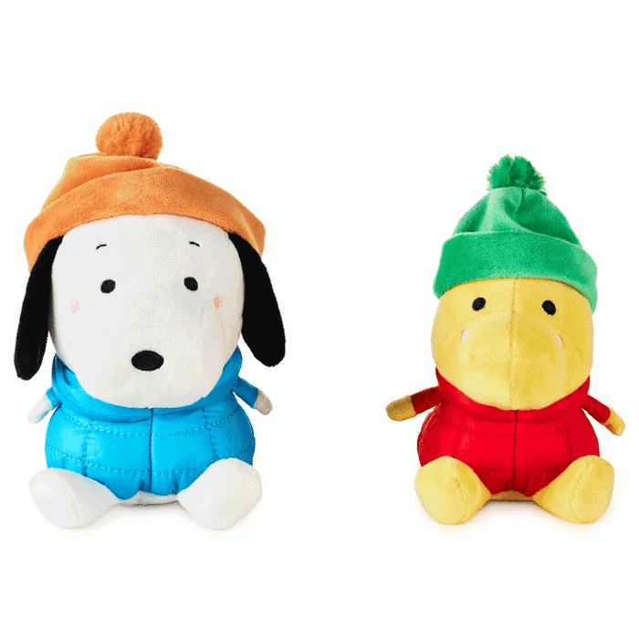 Two plush toys, one with an orange hat and blue outfit, the other with a green hat and red outfit, on a white background.
