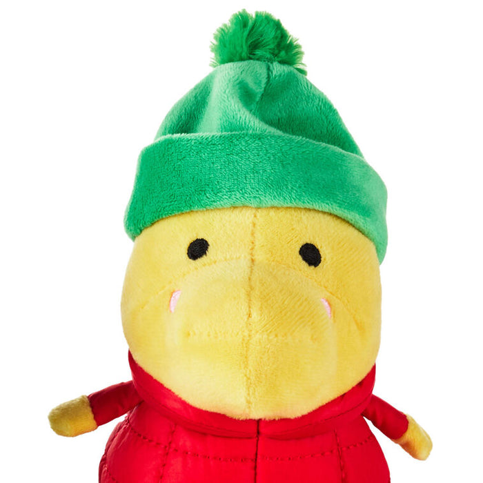 Plush toy duck wearing a green hat and red outfit on a white background