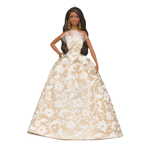 Barbie doll wearing a beige and white floral gown on a white background