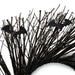 Black artificial bare tree branches with two glittery bat decorations on a white background.