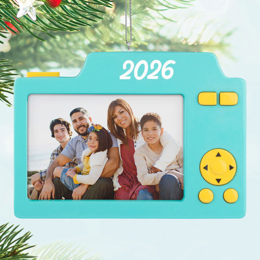 Teal camera-shaped ornament with a family photo and '2026' on a Christmas tree background