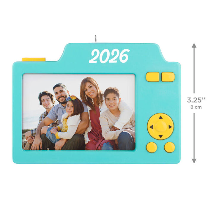 Turquoise camera-shaped photo frame with a family photo and '2026' on a white background