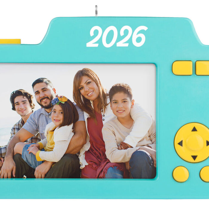 Teal toy camera ornament with a family photo and '2026' on a white background