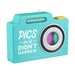 Turquoise camera-shaped candle with 'PICS or it Didn't Happen!' text on a white background