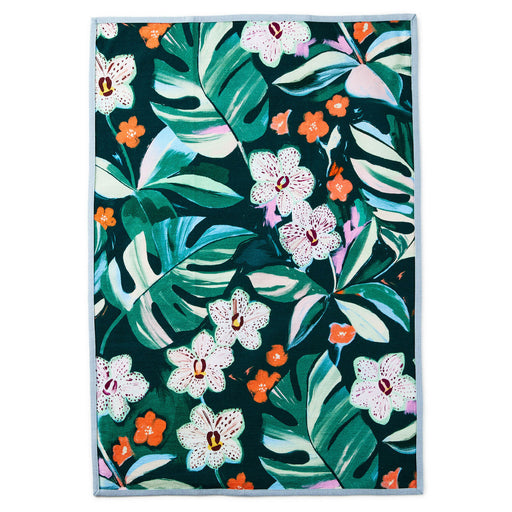 Tropical leaf and flower patterned rug on a white background