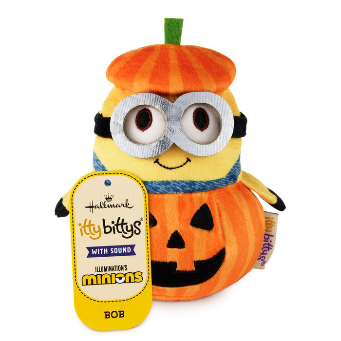 Hallmark Itty Bittys Minions Bob plush toy dressed in a pumpkin costume, featuring a yellow body, orange pumpkin hat and body, black and silver goggles, and a yellow hangtag on a white background.