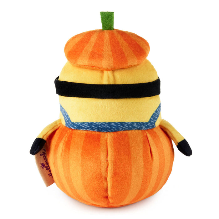 A plush toy shaped like a pumpkin character with orange and yellow vertical stripes, a black band, a blue patterned band, and a small green stem on top, photographed on a white background.