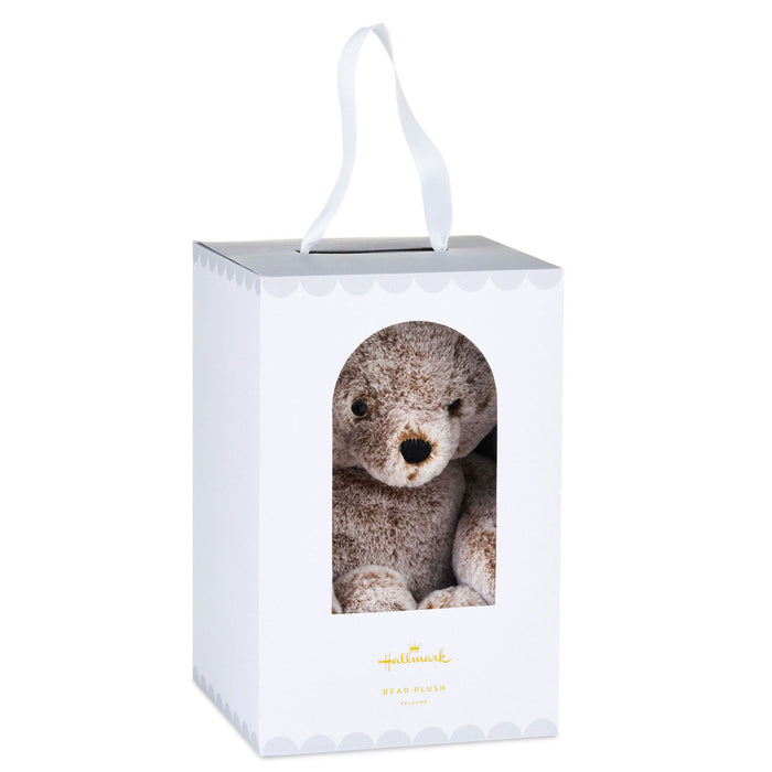 White gift box with a teddy bear inside, featuring a visible brand logo.