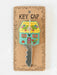 Decorative key cap with house design on a cardboard backing