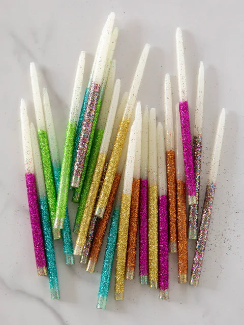 Colorful glittery straws on a white surface