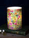 Colorful candle with floral design and 'You are so loved' text on a dark background