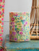 Decorative candle with floral design and 'You are so loved' text on a rustic surface.