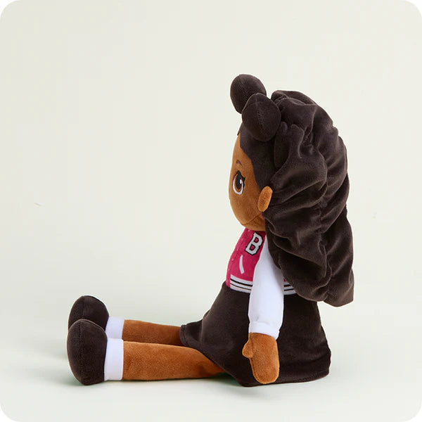 Plush toy of a character with brown hair styled in pigtails, wearing a brown outfit with a white shirt and pink scarf on a light beige background.