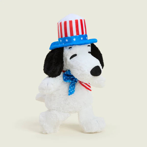 Plush dog toy with American flag hat and bow tie on a beige background