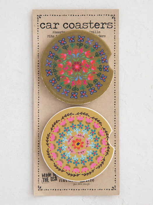 Two floral car coasters on a cardboard backing with text.