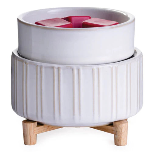 White ceramic planter with wooden feet and pink flowers on a white background