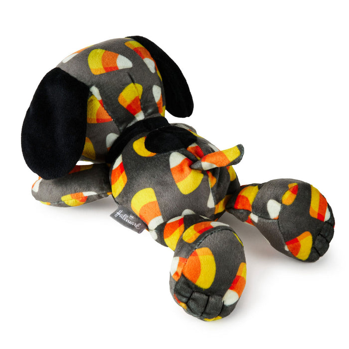 A plush dog toy with a gray body and ears, covered in a candy corn pattern of orange, yellow, white, and black. The toy is photographed on a clean white background.
