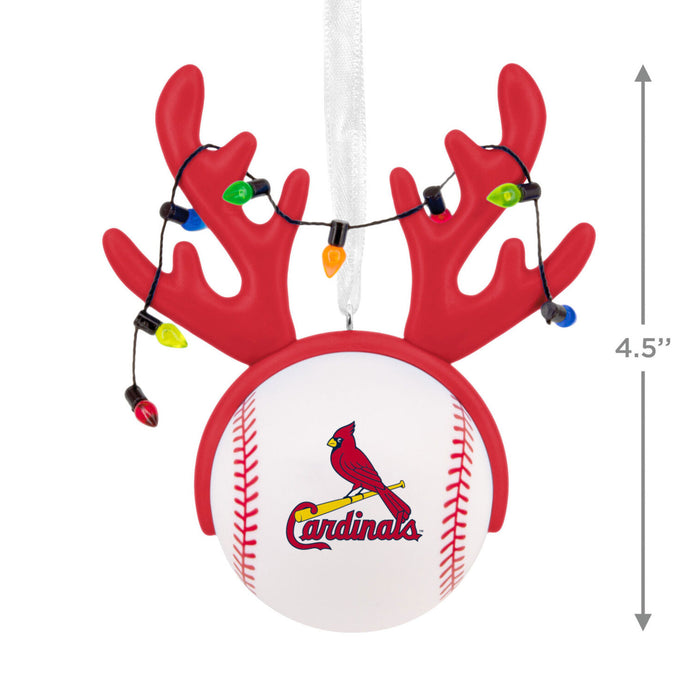 A Cardinals-themed Christmas ornament shaped like a baseball with red antlers and hanging string lights, shown on a white background with a 4.5-inch size marker.