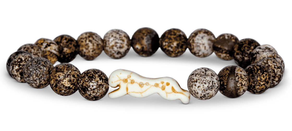 Bracelet with brown beaded design and a white and gold cat figure on a white background