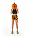 A woman stands against a white background wearing black athletic shorts with an orange pumpkin print and the brand name 'Pumpkinella' on the waistband, holding a carved orange pumpkin to her face.