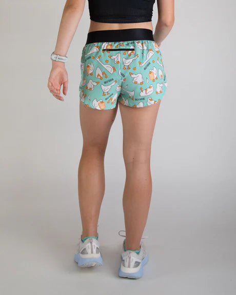 Person wearing a patterned teal shorts on a plain background
