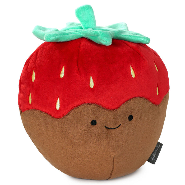 Plush toy shaped like a strawberry with a smiling face on a white background