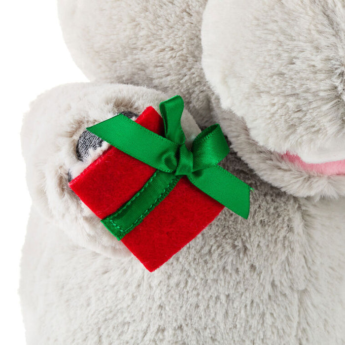 Plush toy with a red gift box and green bow on a white background