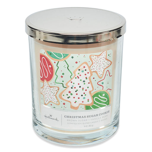 Candle with a Christmas-themed cookie label on a white background