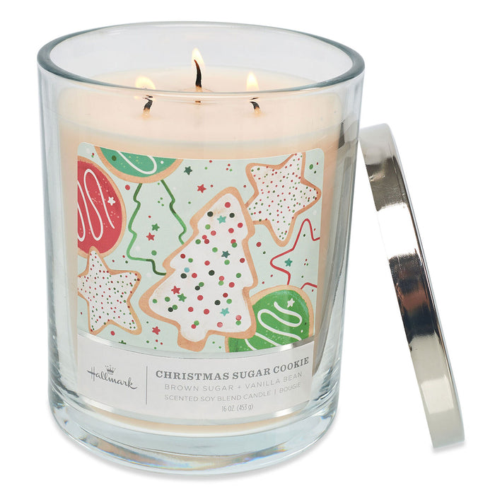 Candle in a glass jar with a Christmas-themed cookie label on a white background