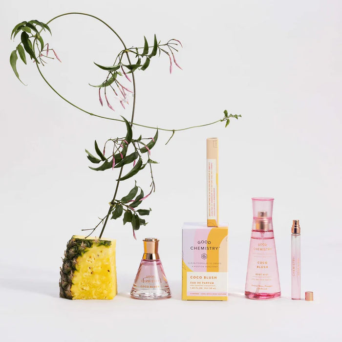 Perfume bottles and packaging with a pineapple and plant on a light background