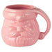 Pink ceramic mug shaped like a face with a handle on a white background