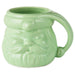 Green ceramic mug shaped like a face with a bow tie on a white background