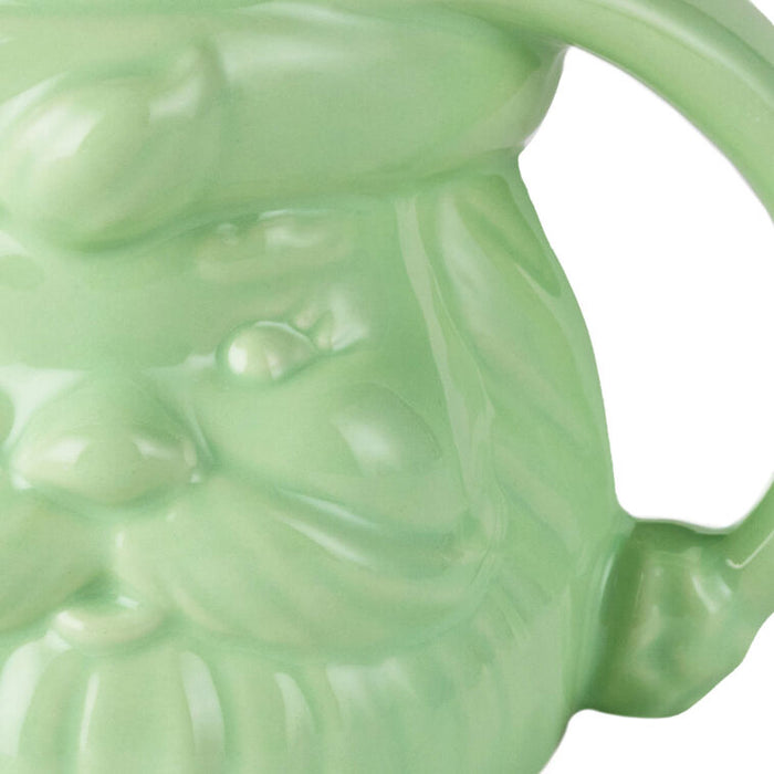 Green ceramic mug with a face design on a white background