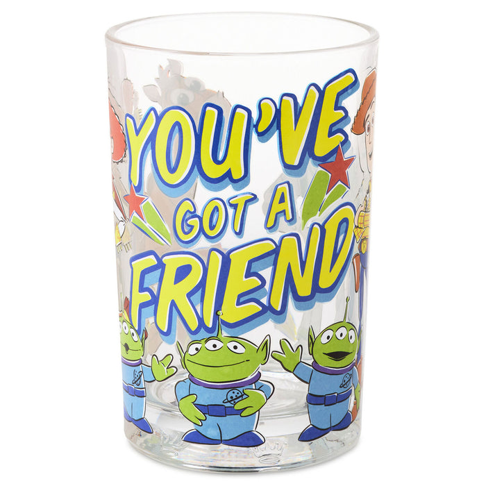 A clear glass tumbler featuring a colorful 'You've Got a Friend' design from Toy Story, with green alien characters and bold yellow text outlined in blue, on a white background.