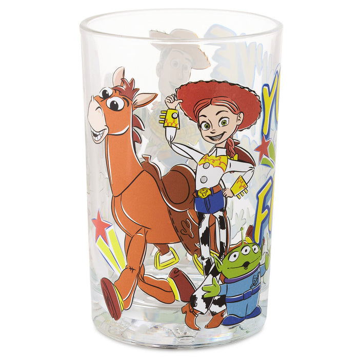 A clear glass tumbler featuring a colorful printed design of Toy Story characters, including Woody, Buzz Lightyear, and Jessie, on a white background.