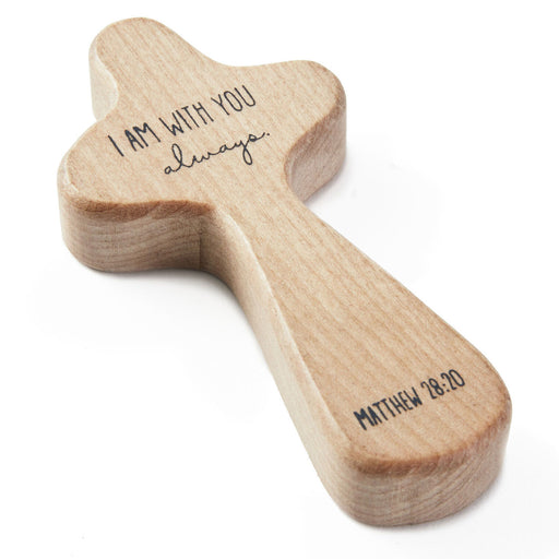 Wooden cross-shaped object with engraved text on a white background