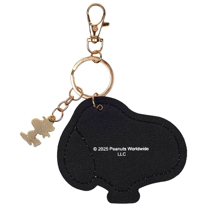 Black keychain shaped like a piggy bank with a gold tag on a white background