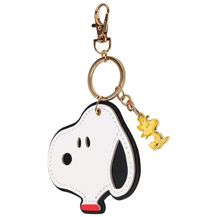 Keychain shaped like a dog with a gold tag on a white background