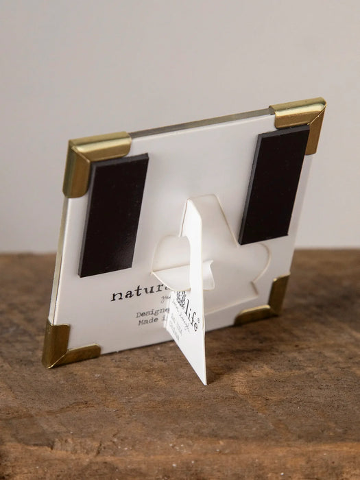 Small photo frame with gold accents on a wooden surface