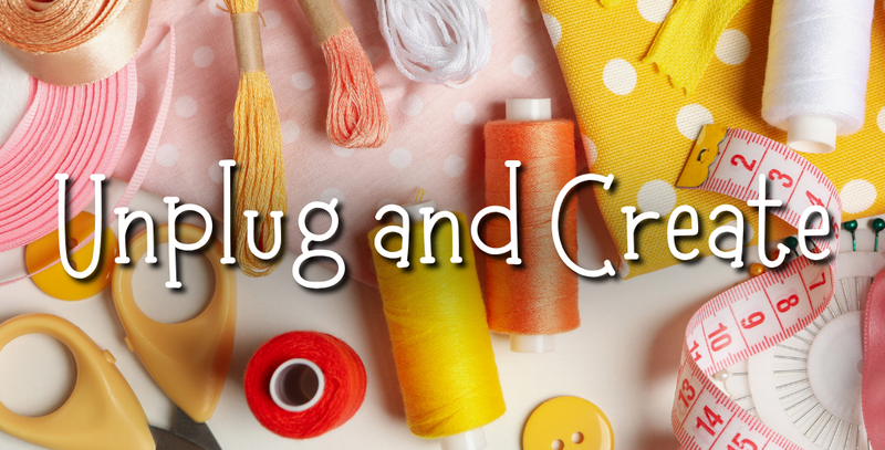 A styled flat-lay of sewing and crafting supplies on a pink polka-dot background, including spools of thread in yellow, orange, red, and white, scissors, buttons, ribbon, and a measuring tape. Large overlaid text reads 'Unplug and Create'.