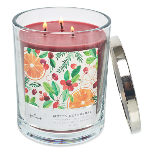 Three-wick candle in a glass jar with a colorful label on a white background