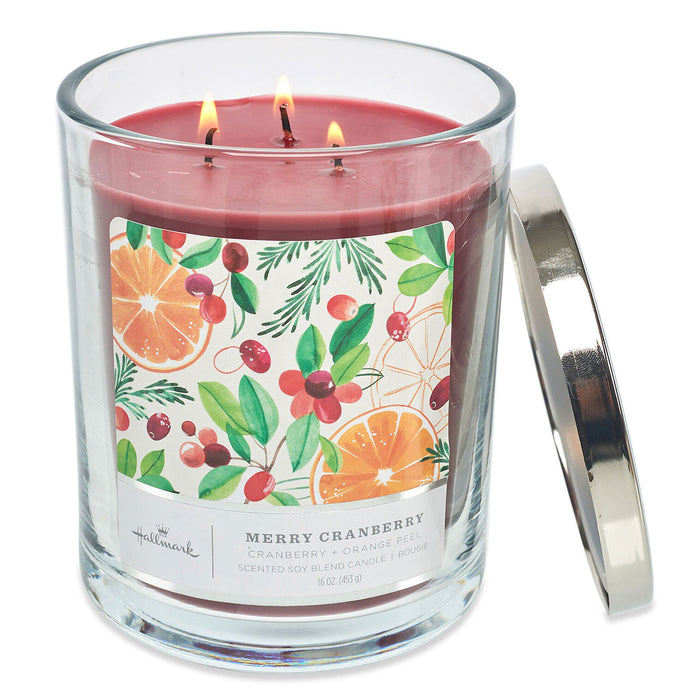 Three-wick candle in a glass jar with a colorful label on a white background