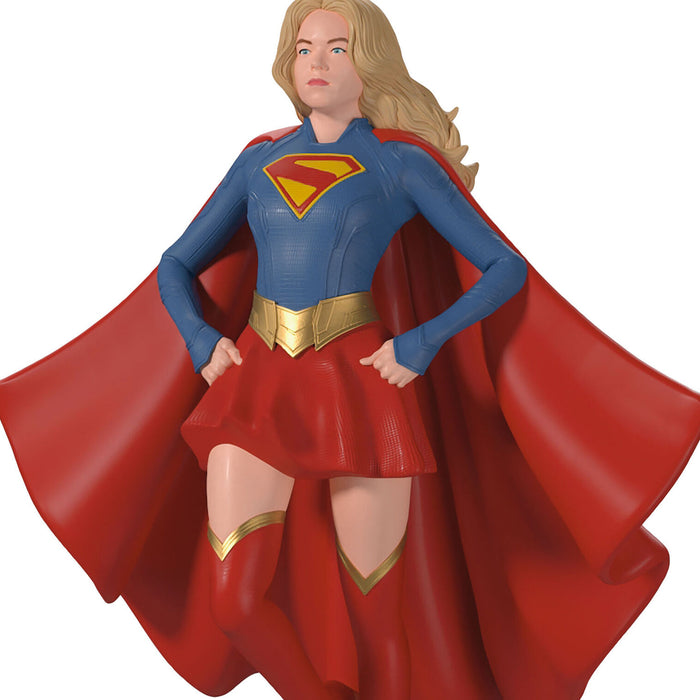 Supergirl figurine with red cape and blue costume on a white background
