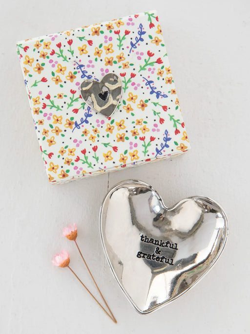 Silver heart-shaped trinket dish with 'thankful & grateful' text on a floral-patterned box.