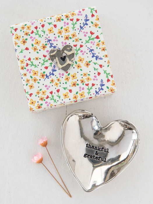 Silver heart-shaped trinket dish with 'thankful & grateful' text on a floral-patterned box.
