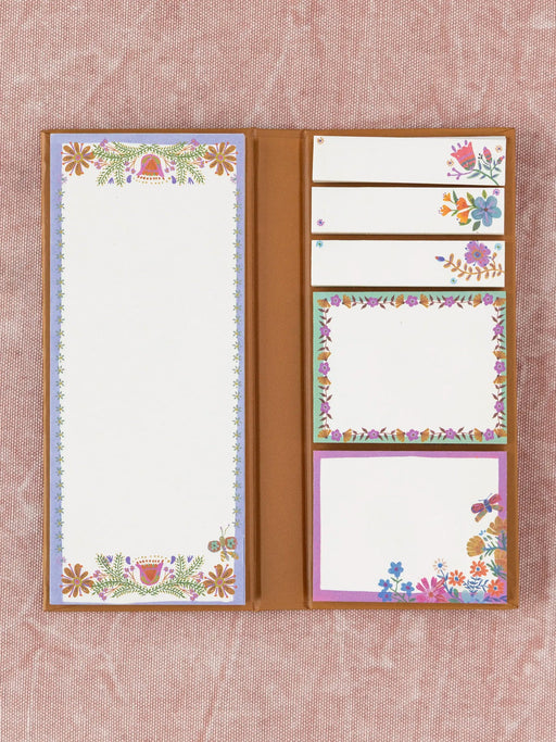 Set of stationery items with floral designs on a textured pink background