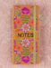 Notebook with floral design and 'NOTES' text on a pink background